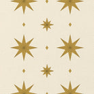 Close-up of the Stars Christmas table runner print in ivory and gold on cotton, showing large gold eight-pointed stars