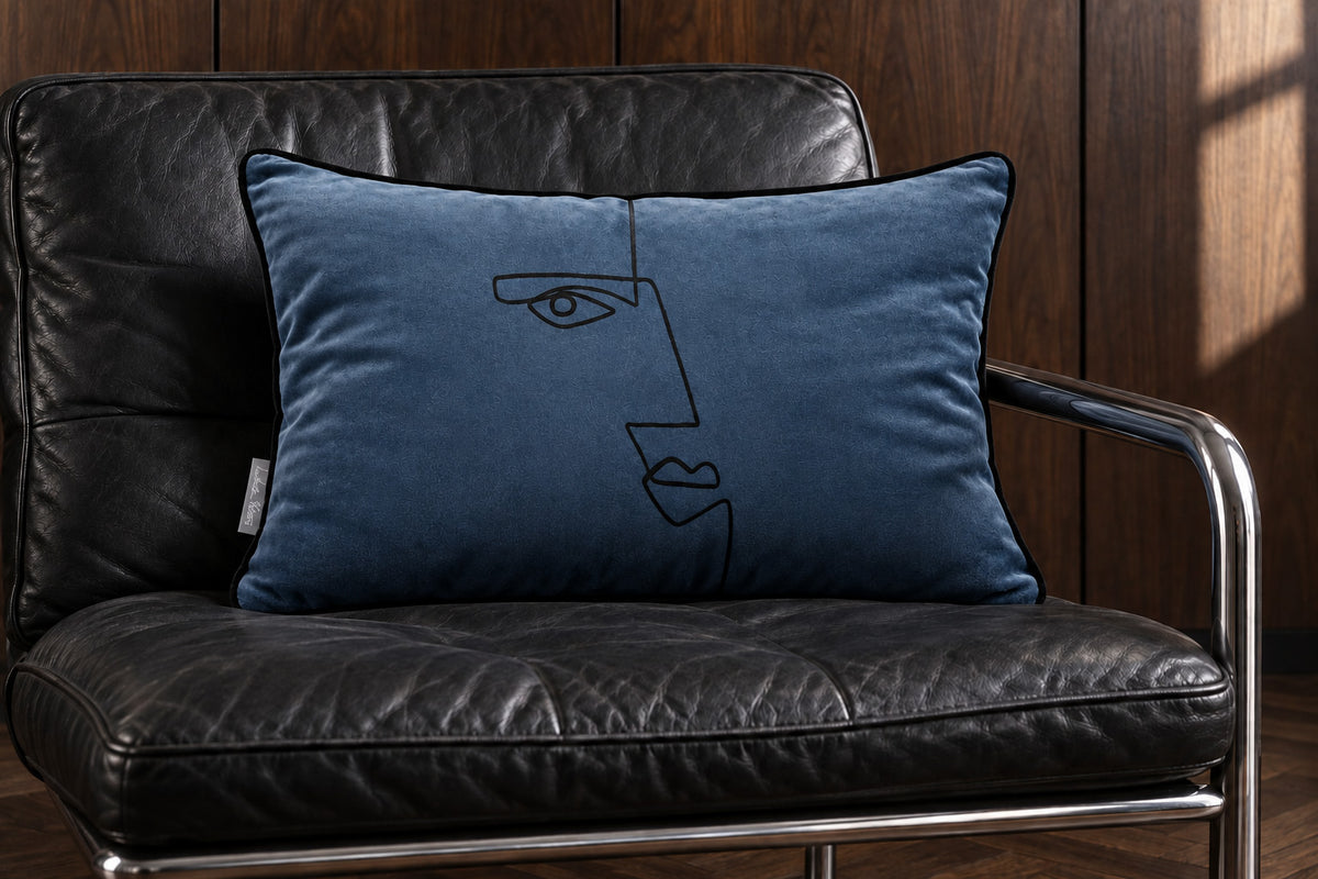 Petrol Blue rectangular Angular Face velvet cushion on a black leather and chrome lounge chair against walnut panelling.