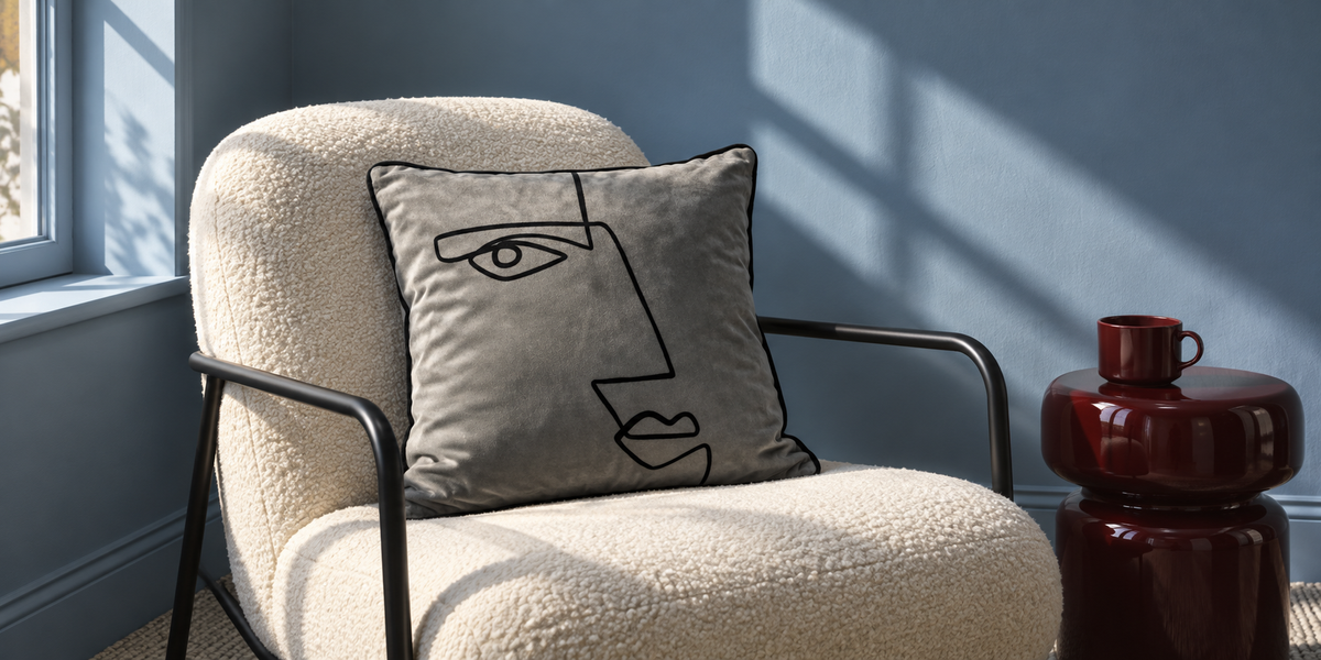 Beluga Angular Face velvet cushion on an ivory chair in a blue painted room.