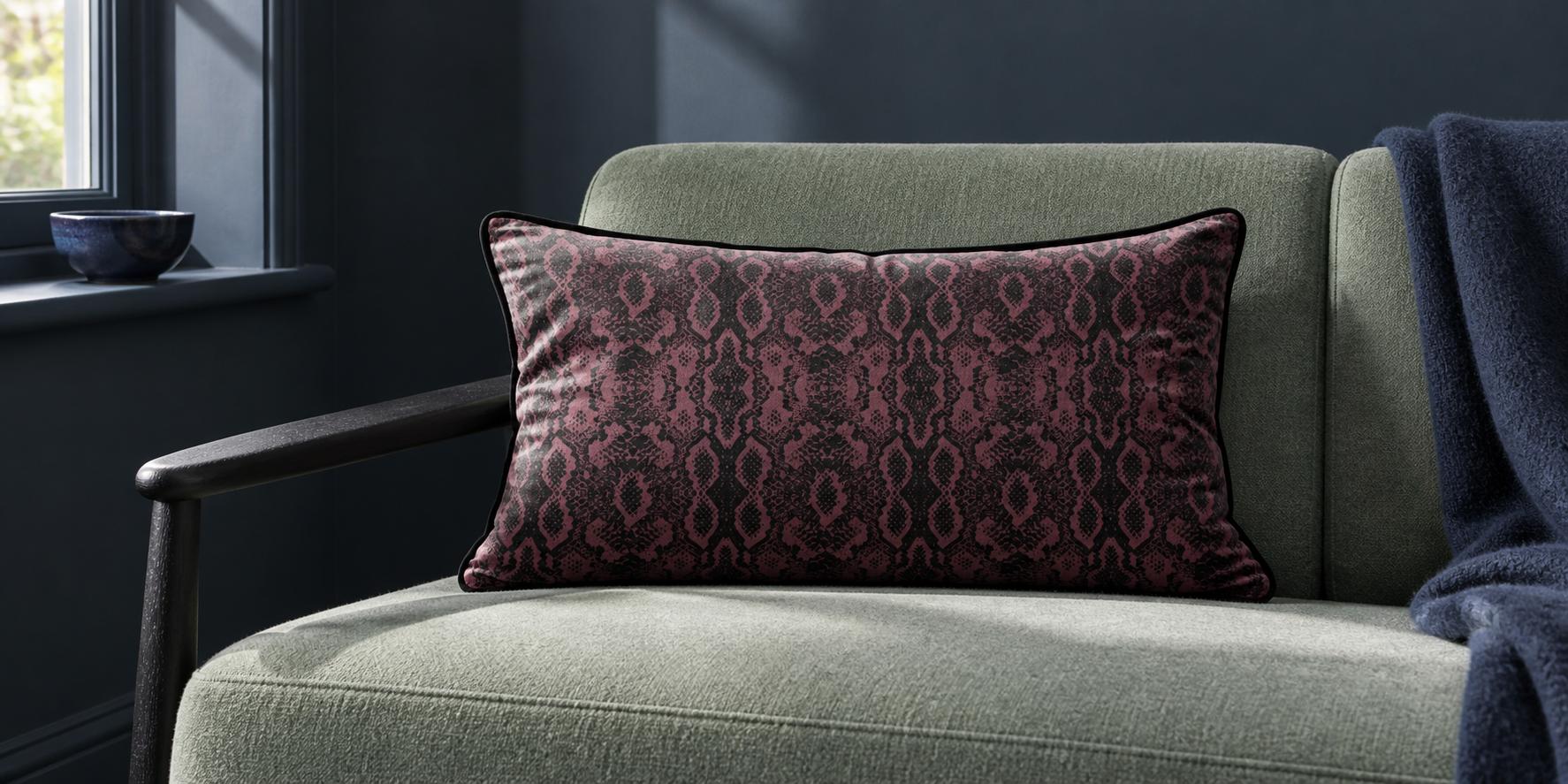 Italian Grape Exotic Snake rectangular velvet cushion on a pale green chair in a dark blue room.