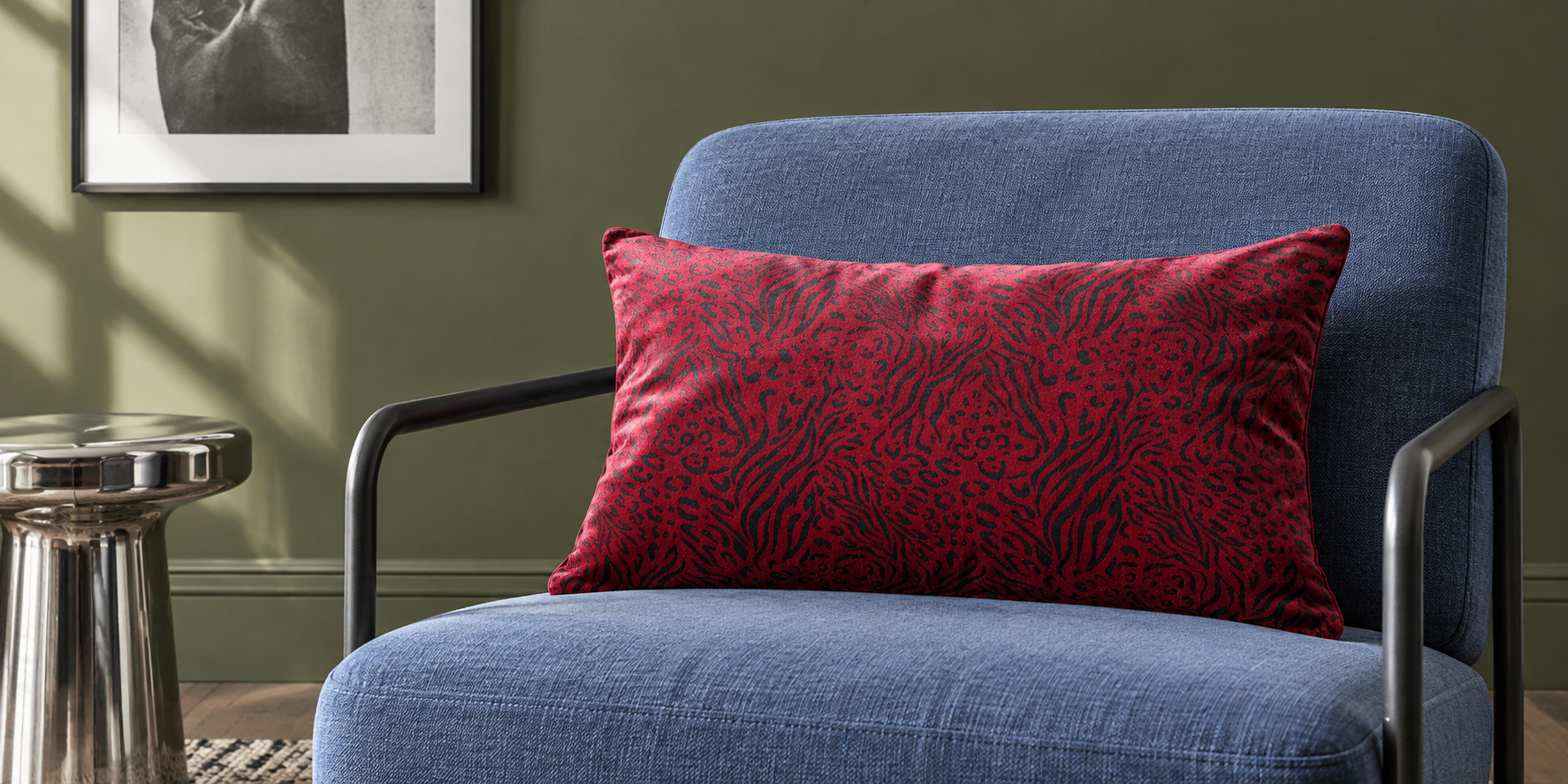 Raspberry Red Animal Fusion rectangular velvet cushion on a cornflower blue chair in an olive room.