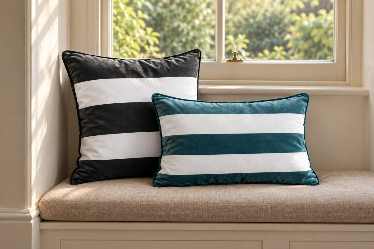 Charcoal square and Teal rectangular striped velvet cushions on a linen window seat beneath a sash window.