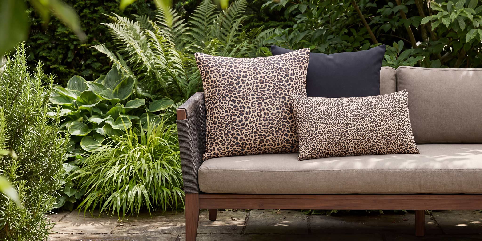 Leopard-print outdoor cushions in square and rectangular sizes styled on a garden sofa