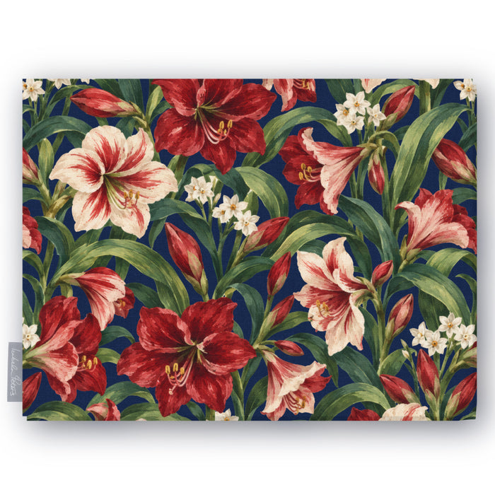 Navy Amaryllis Christmas tablecloth folded on white, showing amaryllis flowers among long leaves