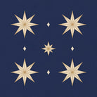Close-up of the Stars Christmas napkin print in navy and gold on cotton, showing gold eight-pointed stars