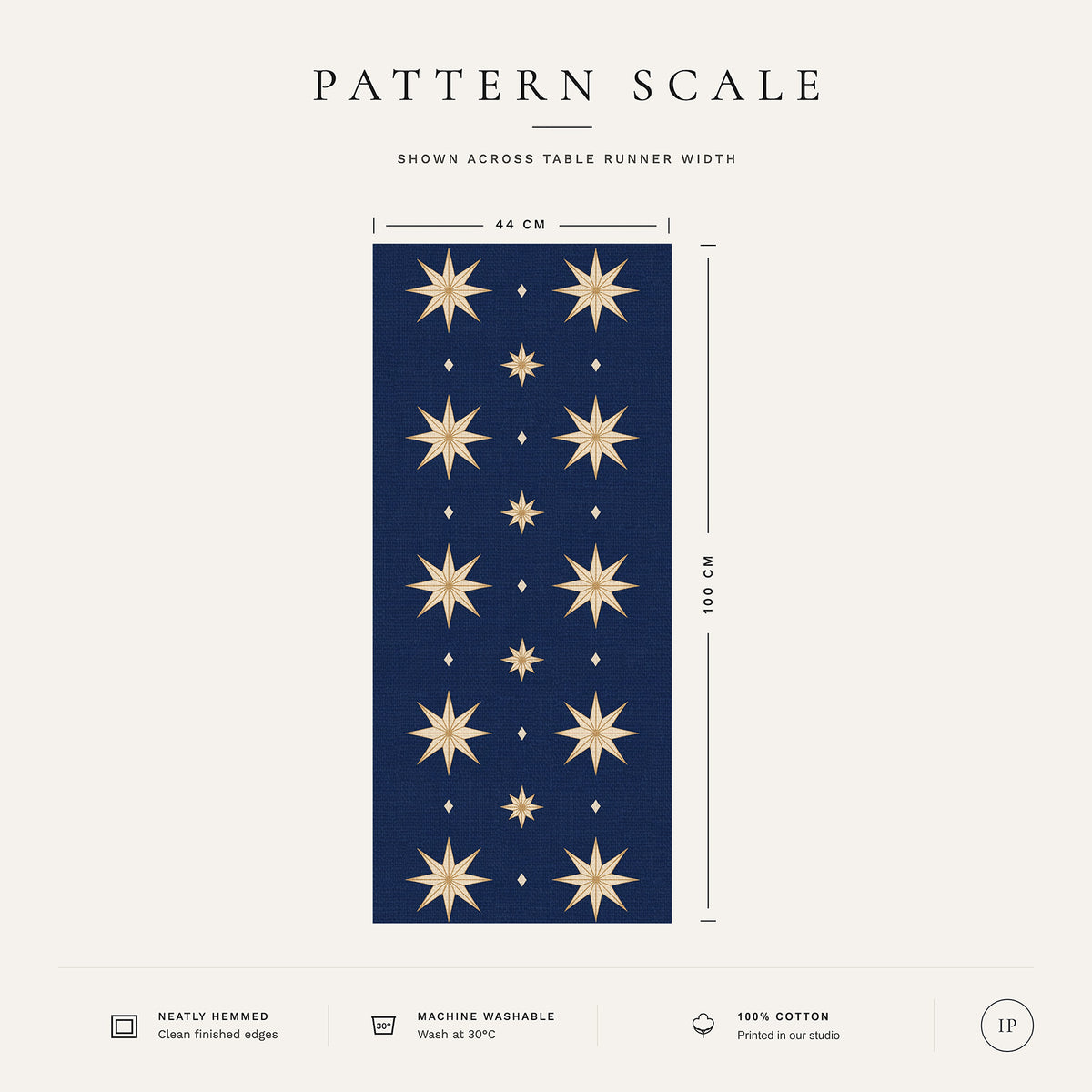 Pattern scale of the Stars Christmas table runner in navy and gold across its 44 cm width, with care notes