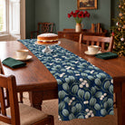 Mistletoe Christmas table runner in Navy, styled on a wooden table with a softly draped end in a daylight Christmas room.