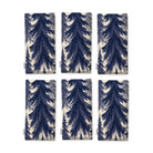 Spruce Stand Christmas napkins in navy on ivory, set of six, folded on white, showing the same spruce trees