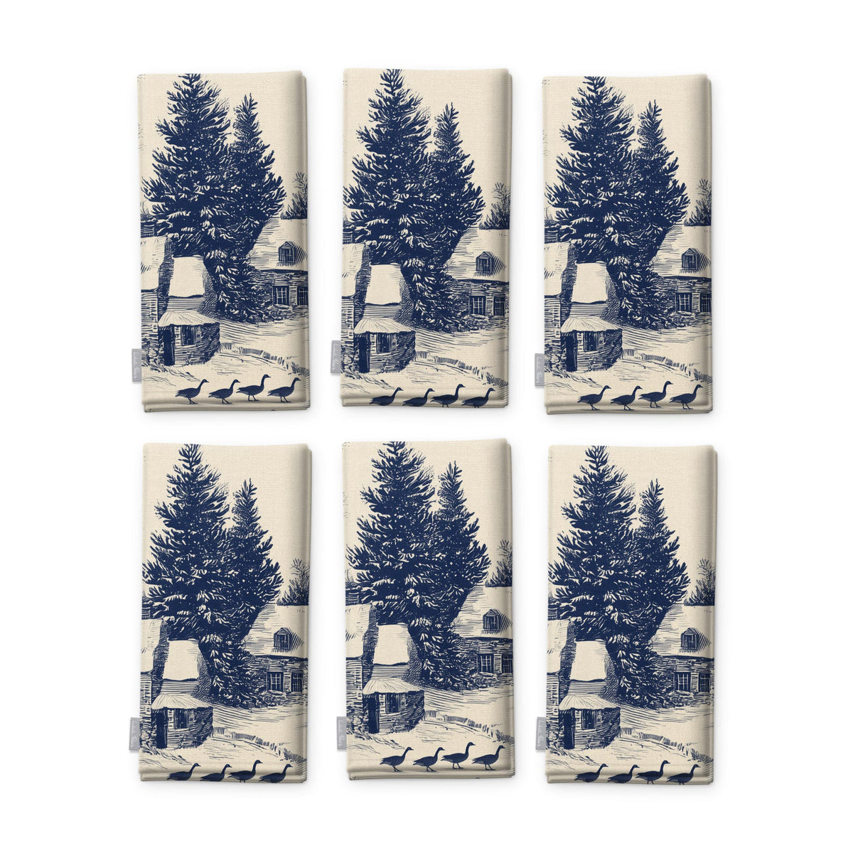 Village Toile Christmas napkins in navy on ivory, set of six, folded on white, showing the same fir tree and snowy cottage