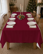 Plain burgundy Christmas tablecloth on a laid table
