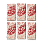 Pine Bough Christmas napkins in red on ivory, set of six, folded on white, showing the same pine cone on a bough