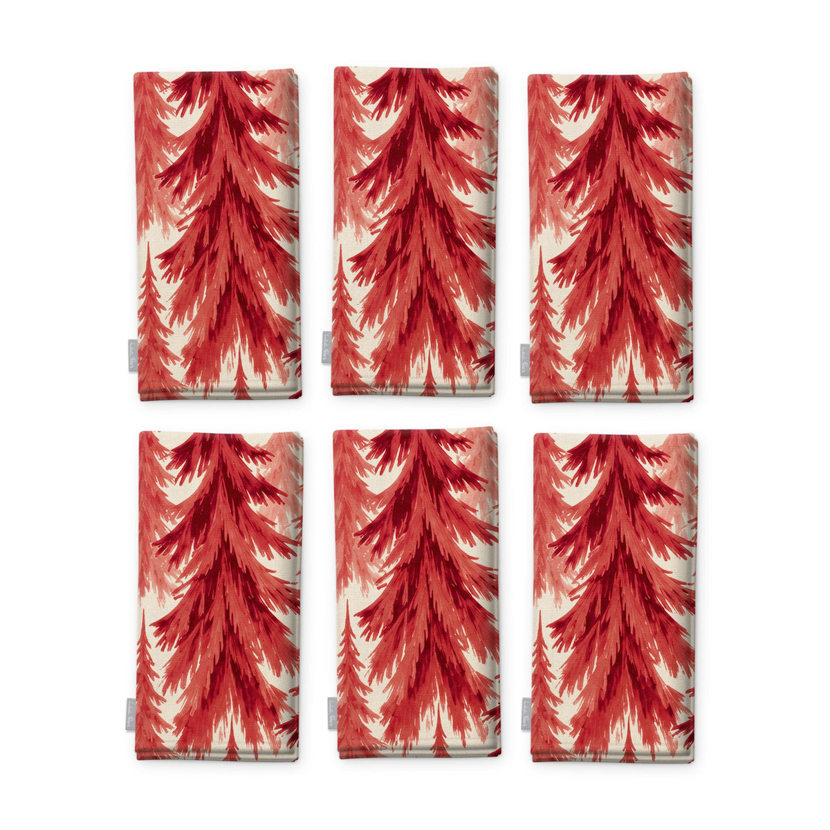 Spruce Stand Christmas napkins in red on ivory, set of six, folded on white, showing the same spruce trees