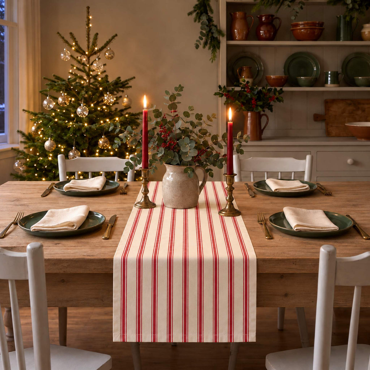 Ticking Stripe Christmas table runner in Red on ivory on a bare wooden table in a candlelit Christmas dining room.