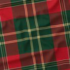 Close-up of the red tartan Christmas tablecloth, showing the red and deep green check and fine ivory and gold lines