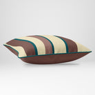 Angled view showing the front and Cocoa plain reverse of a Ribbon Stripe rectangular cushion in Cocoa & Teal, finished with Deep Teal piping.