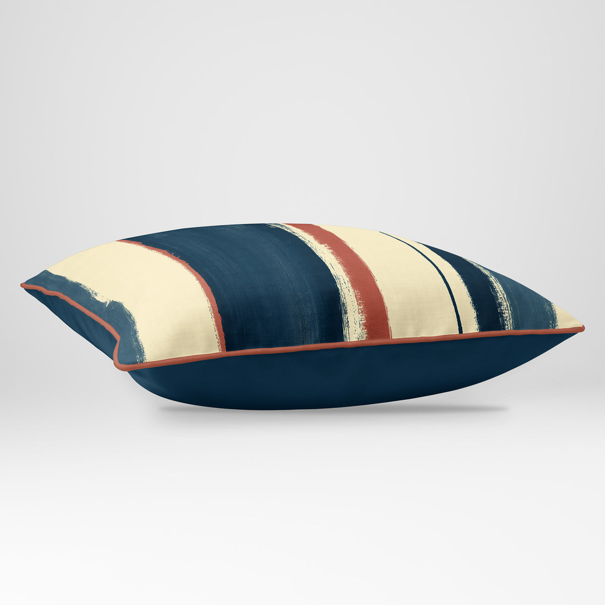 Angled view showing the front and Deep Teal plain reverse of an Unequal Stripe rectangular cushion in Teal & Persimmon, finished with Persimmon piping.